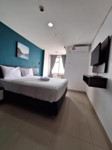 een slaapkamer met een groot bed met een blauwe muur bij izicozi Hotel Jababeka in Cibeber