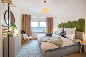 um quarto com uma cama com uma grande cabeceira verde em NEU: 100m² - ideal für Familien/Geschäftsr. - HBF em Koblenz