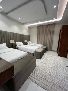 a hotel room with two beds and a couch at شقة فندقية راقيه ثلاث غرف نوم in Jeddah