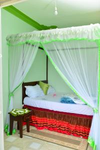 a bed with a canopy in a room at Zion Camp in Entebbe