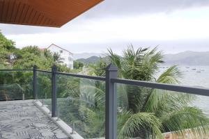 a balcony with a view of the water at Eroska Villa in Thôn Cát Lợi