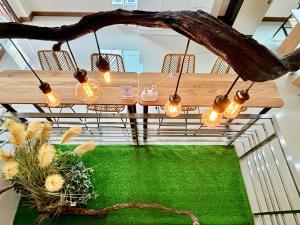 Willow Pillow Guest House & Poshtel في شومفون: طاولة مع أضواء متدلية من فرع شجرة