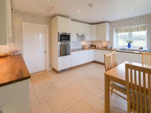 a kitchen with white cabinets and a table and a dining room at 2 Bed in Harrogate District HH087 in Stainburn
