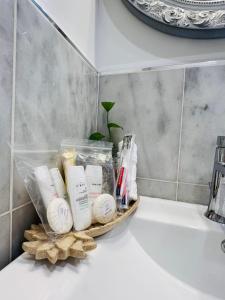 a basket of toiletries sitting on top of a sink at Eleni’s Charming Studio in North Beach +26 photos