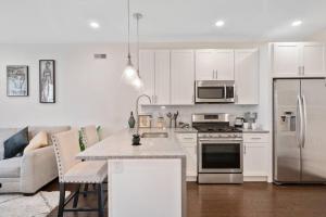a kitchen with white cabinets and stainless steel appliances at Luxurious & Spacious 3Bed/3Bath with Outdoor Patio in Philadelphia
