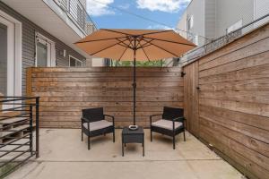 a patio with two chairs and a table with an umbrella at Luxurious & Spacious 3Bed/3Bath with Outdoor Patio in Philadelphia