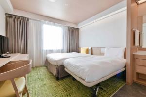 大津町にあるベッセルホテル熊本空港のベッドとデスクが備わるホテルルームです。