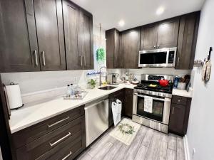 a kitchen with wooden cabinets and a stove top oven at Eleni’s Charming Studio in North Beach