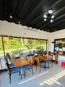 a restaurant with tables and chairs and a large window at Canto Tièro Suite Room in Mabini