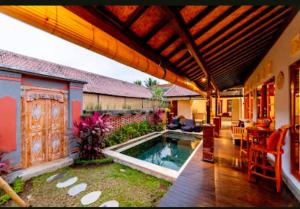 um pátio com uma piscina e uma casa em Ardea Villa Ubud em Ubud