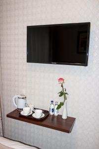 un estante con TV y una flor en un jarrón en Silk Way en Almaty