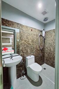 a bathroom with a toilet and a sink and a shower at The JRJF Hotel near Tagum Terminal in Tagum
