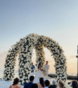 a bride and groom standing under an arch of flowers at CAMATAJUA BARU HOUSE in Playa Blanca +51 photos