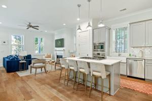 a kitchen with white cabinets and a kitchen island with bar stools at Shem Creek House- 5 Mins to Downtown & Beach in Charleston