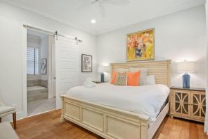 a bedroom with a large bed and a bathroom at Shem Creek House- 5 Mins to Downtown & Beach in Charleston