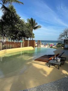 una piscina con mesa y sillas en el agua en Casa Canoa Hotel Boutique à Beira-mar com Piscina e Café da manhã, en Guarujá