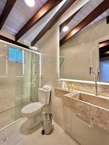 uma casa de banho com um WC, um chuveiro e um lavatório. em Casa Canoa Hotel Boutique à Beira-mar com Piscina e Café da manhã no Guarujá