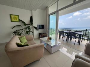 a living room with a couch and a table with a balcony at Creole Pearl Self-Catering in Victoria