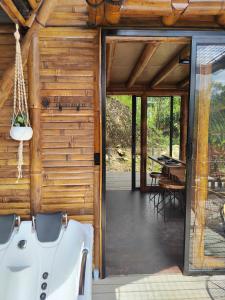 an open door of a wooden house with a porch at Senz Glamping - Mindo in Mindo