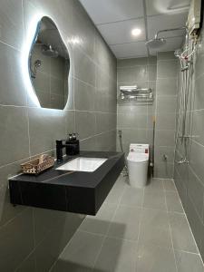 y baño con lavabo, espejo y aseo. en December Homestay Studio, en Ho Chi Minh