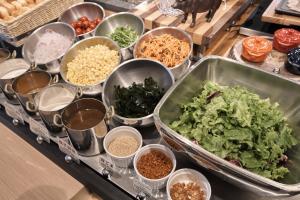 ein Buffet mit Schalen mit Gemüse und anderen Zutaten in der Unterkunft Almont Hotel Kyoto in Kyoto