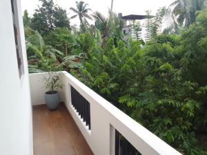 a balcony with trees and plants on a building at Lakmali Homestay 2 in Weligama