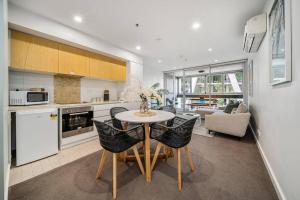 Una cocina y un comedor con mesa y sillas. en Bliss at Balfours Adelaide, en Adelaida