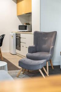 a blue chair in a kitchen with a microwave at Bliss at Balfours - CBD Escape with Pool & Hot Tub in Adelaide