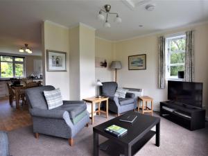 a living room with two chairs and a tv at 2 Bed in Pitlochry CA084 in Struan