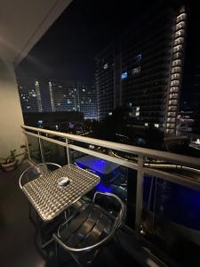 een tafel en stoel op een balkon met een skyline van de stad bij Azure Urban Resort Staycation Miami Tower near NAIA with wifi and Netflix - Js Haven in Manilla