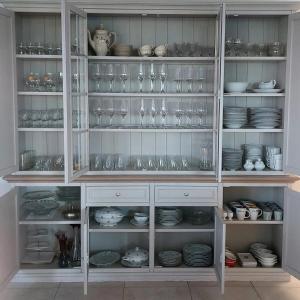 a white cabinet filled with glasses and dishes at Florentinus met hottub, afgesloten tuin en overdekt terras in Veurne