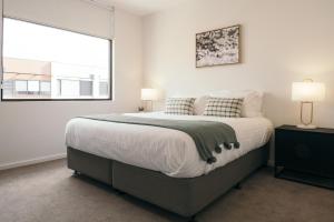 Un dormitorio con una cama grande y una ventana en Lusso - Rooftop Views 3BR 3BTH 4 Level Townhouse en Adelaida