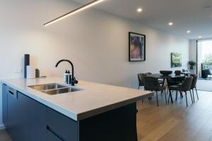 a kitchen and dining room with a sink and a table at Lusso - Rooftop Views 3BR 3BTH 4 Level Townhouse in Adelaide