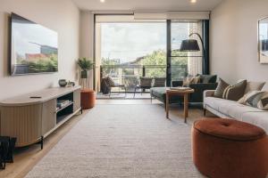 a living room with a couch and a table at Lusso - Rooftop Views 3BR 3BTH 4 Level Townhouse in Adelaide