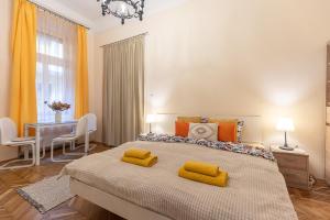 a bedroom with a large bed with yellow pillows on it at Harmony & Cute - central apartments in Budapest
