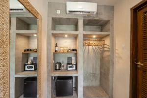a room with a mirror and a kitchen with appliances at Village Bali in Uluwatu