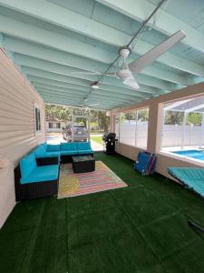 a living room with blue furniture and a pool at Pink Sunshine: Private Heated Pool and Spa, Close to Beach in Largo