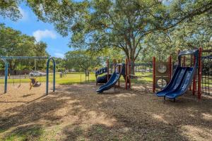 a playground in a park with a slide at Pink Sunshine: Private Heated Pool and Spa, Close to Beach in Largo