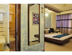 昌迪加爾的住宿－Hotel The Tulip ,Chandigarh，一间卧室配有一张床和镜子