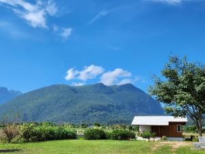 a small house with a mountain in the background at Stay Day Off at Chiang Dao in Ban Mae Khon