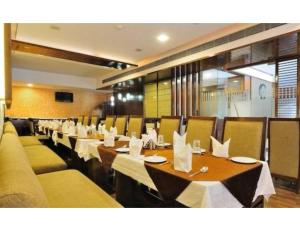a restaurant with long tables and chairs with white napkins at Hotel The Tulip ,Chandigarh in Chandīgarh