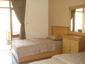 1 dormitorio con 2 camas y espejo en Lembah Rinjani Villa & Resto by ecommerceloka, en Sembalun Lawang