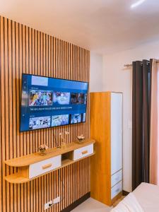 a bedroom with a television on a wooden wall at Sea & City lights View in Lapu Lapu City