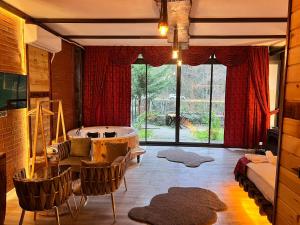 a living room with a tub and a table and chairs at Esinti Bungalows Otel in Çamlıhemşin