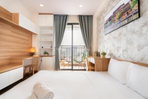 a bedroom with a large white bed and a desk at Olala Saigon Apartment - Rivergate Residence in Ho Chi Minh City