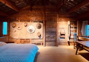 - une chambre dotée d'un mur en bois et d'un lit dans l'établissement Qushe Snowy Mountain View Art B&B, à Lijiang