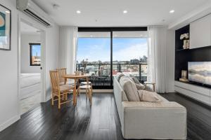 a living room with a couch and a table at Elegant Collingwood Apartment with City Views in Melbourne