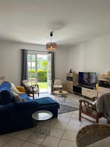 een woonkamer met een blauwe bank en een tv bij Villa Nicky in Le Tampon