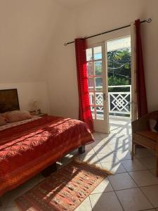 una camera da letto con un letto e una porta scorrevole in vetro di Villa entre Mer et Montagne a Le Tampon Altre 6 foto