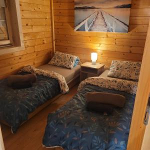 two beds in a cabin with a picture on the wall at Domki nad morzem Jula in Wrzosowo